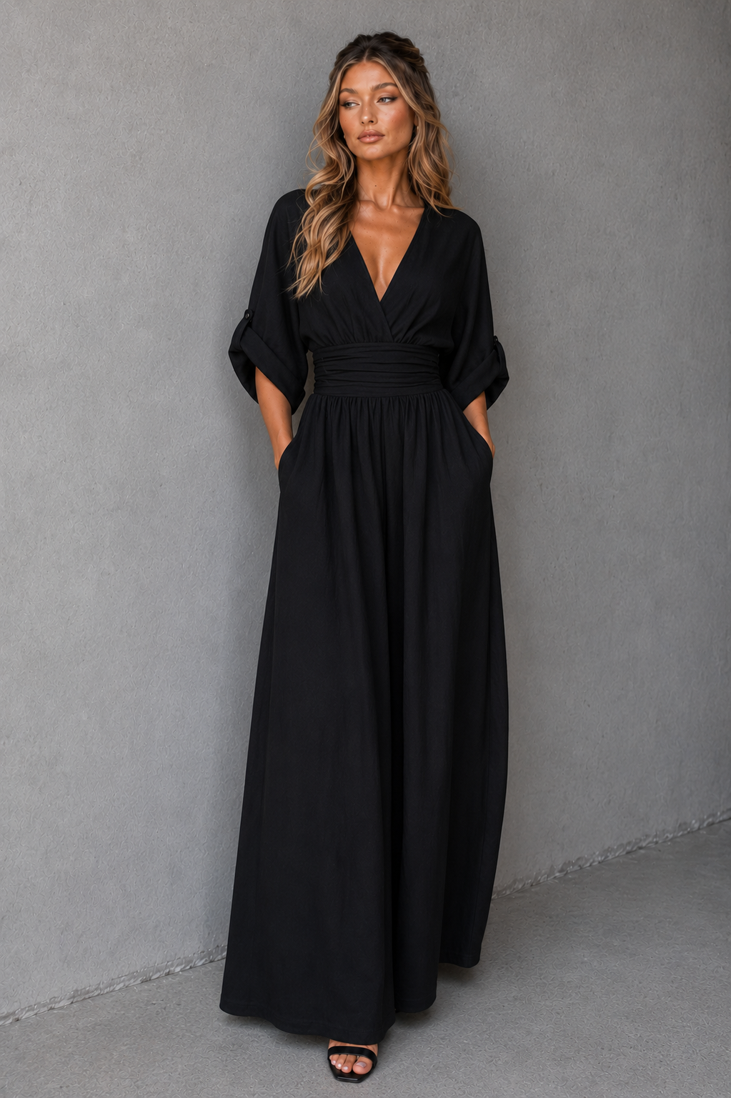 Woman wearing a black dress against a gray background