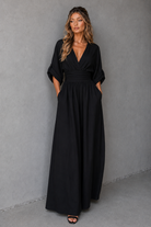 Woman wearing a black dress against a gray background