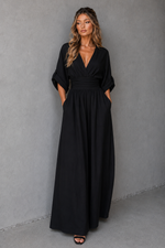 Woman wearing a black dress against a gray background