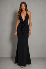 Woman wearing a black evening gown against a gray background
