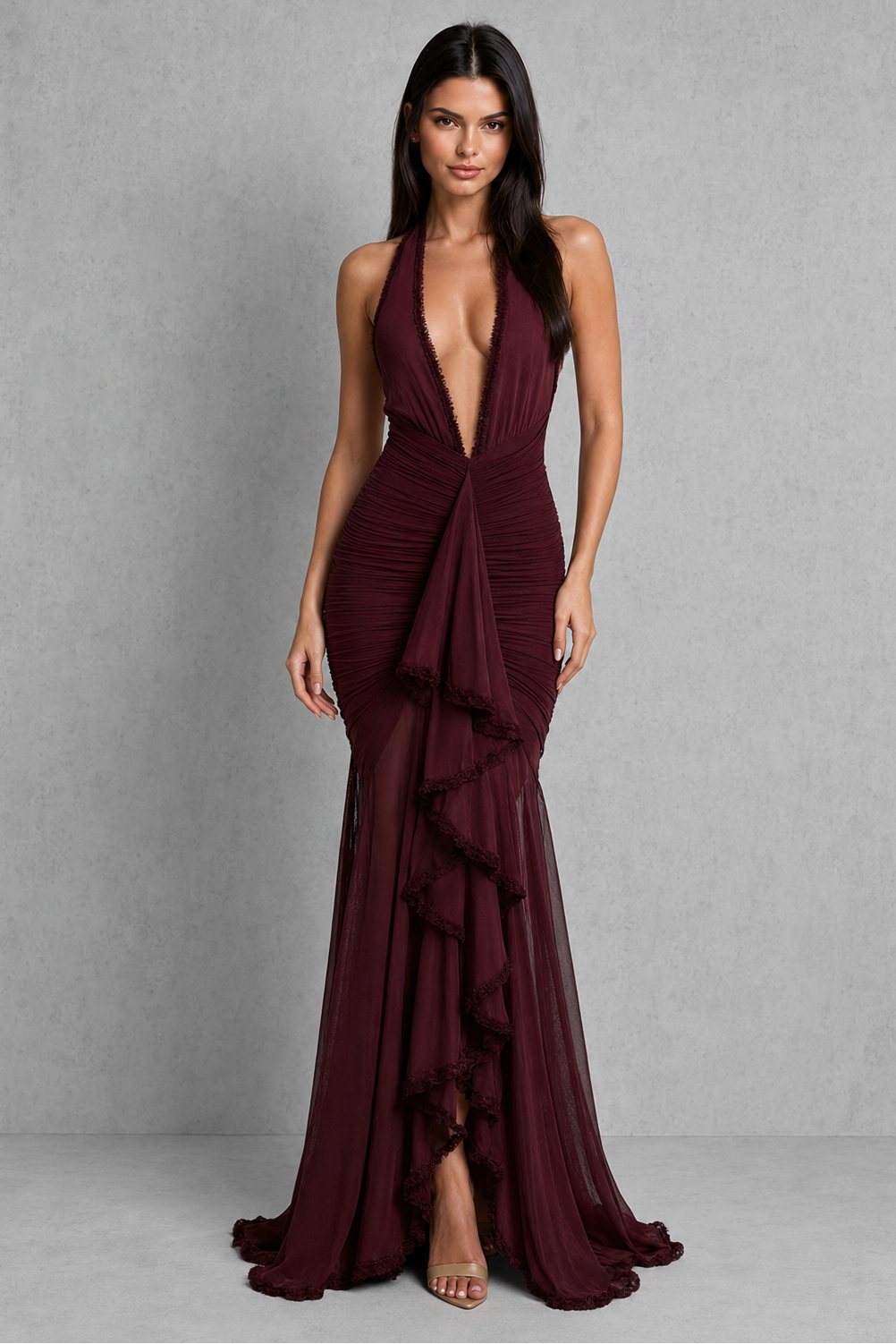 Woman wearing a burgundy evening gown against a gray background