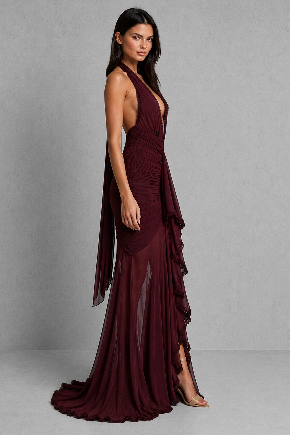 Woman wearing a burgundy evening gown against a gray background