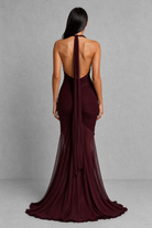 Burgundy evening gown with open back on a gray background