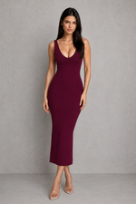Woman wearing a burgundy dress against a gray background