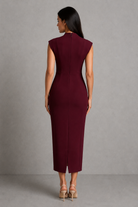 Woman wearing a burgundy dress against a gray background