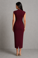 Woman wearing a burgundy dress against a gray background
