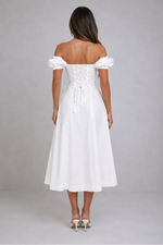 Woman wearing a white off-shoulder dress on a gray background