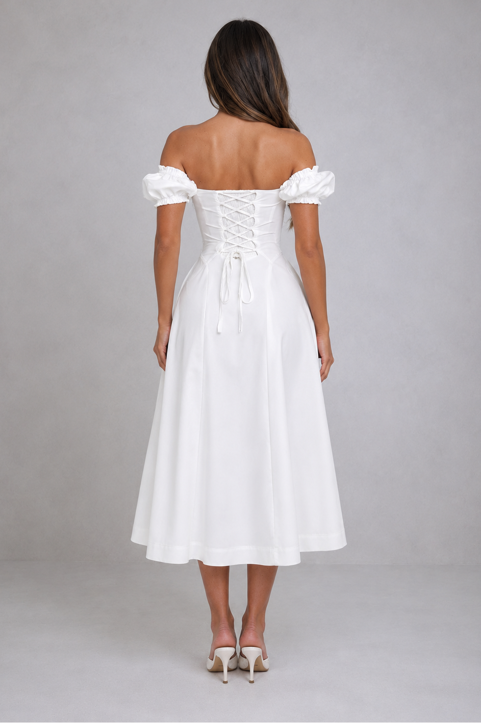 Woman wearing a white off-shoulder dress on a gray background