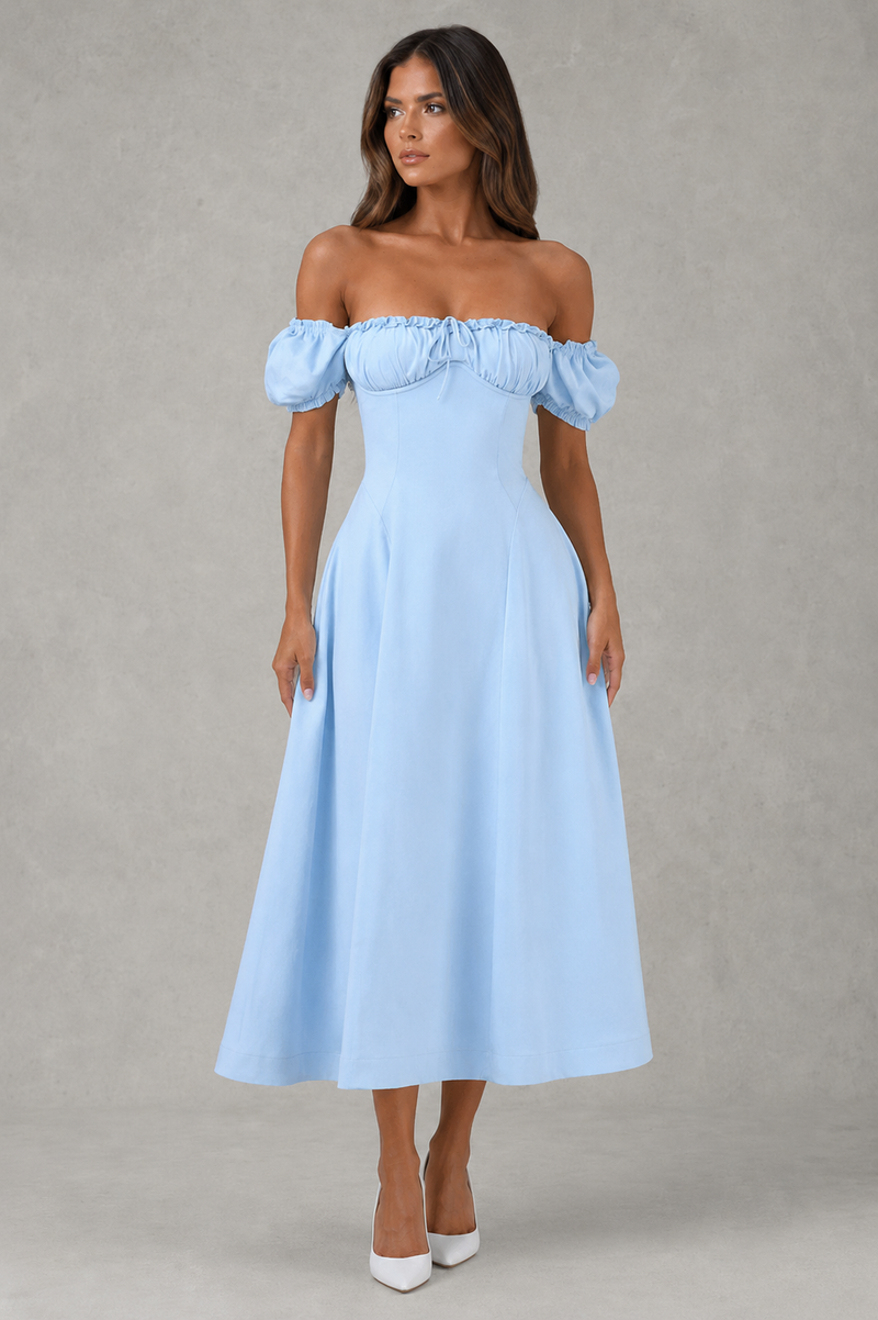 Woman wearing a light blue off-shoulder dress against a gray background