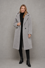 Women's quilted longline coat with a padded design, protective hood, deep side pockets and a relaxed fit, offering warm, lightweight comfort for autumn and winter wear.