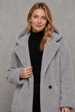 Women's quilted longline coat with a padded design, protective hood, deep side pockets and a relaxed fit, offering warm, lightweight comfort for autumn and winter wear.