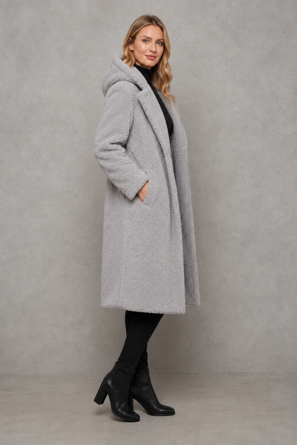 Women's quilted longline coat with a padded design, protective hood, deep side pockets and a relaxed fit, offering warm, lightweight comfort for autumn and winter wear.