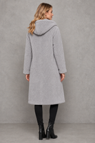Women's quilted longline coat with a padded design, protective hood, deep side pockets and a relaxed fit, offering warm, lightweight comfort for autumn and winter wear.