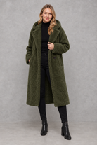 Women's quilted longline coat with a padded design, protective hood, deep side pockets and a relaxed fit, offering warm, lightweight comfort for autumn and winter wear.