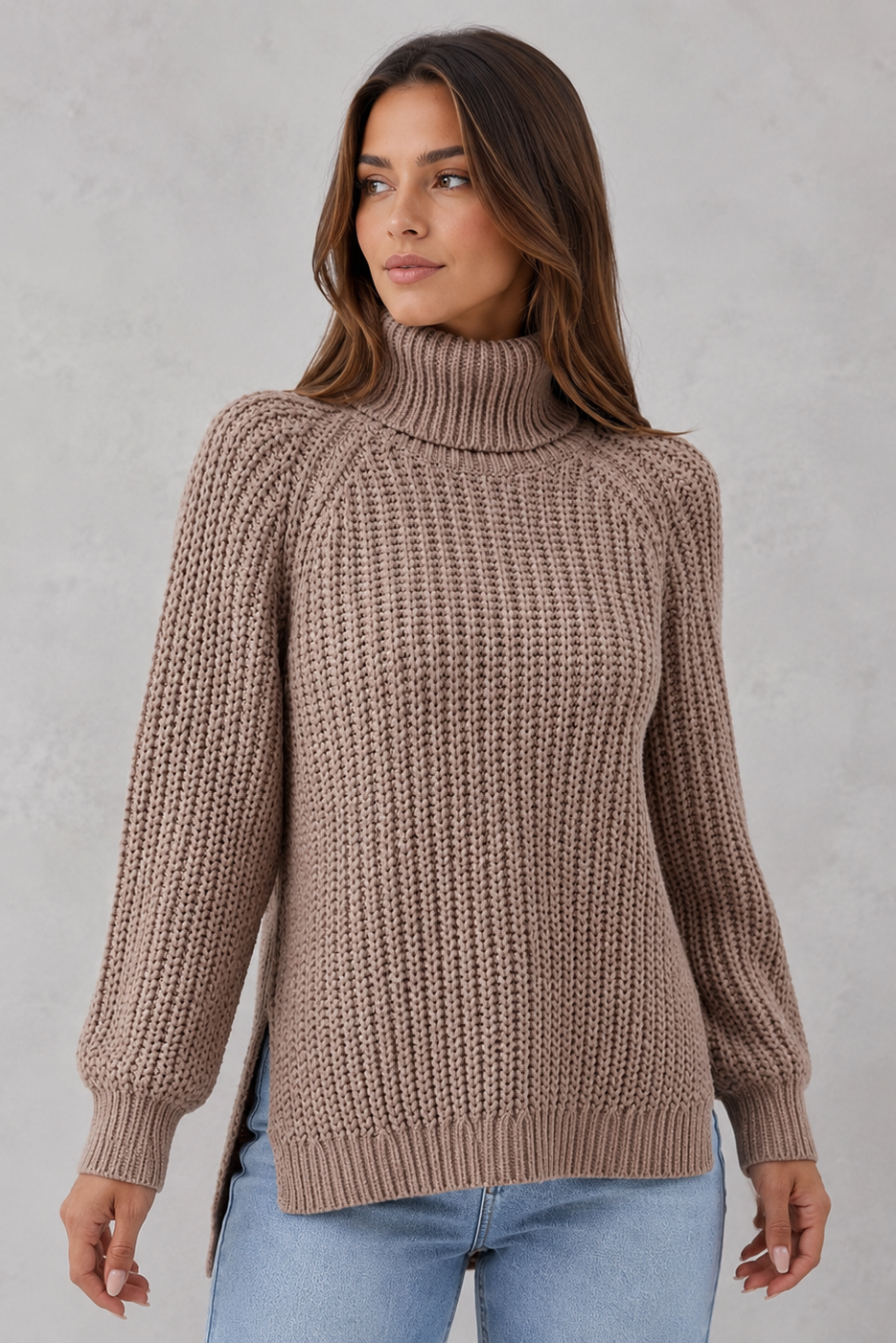 Woman wearing a brown knitted turtleneck sweater against a plain background