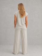 Women's relaxed two-piece lounge set featuring a cap sleeve T-shirt with chest pocket and matching wide leg trousers with an elasticated drawstring waist, crafted from soft breathable fabric for everyday comfort.