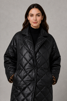 Women’s reversible quilted mid-length coat with a classic plain quilted side and bold leopard-print reverse, featuring lapels and side pockets.