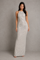 Woman wearing a silver sequin dress against a gray background