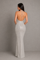Woman wearing a silver sequin gown against a gray background