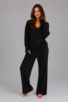 Women's ribbed knit lounge set featuring a relaxed V-neck jumper and matching wide leg trousers in a soft stretch knit, designed for cosy everyday comfort and casual wear.