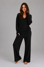 Women's ribbed knit lounge set featuring a relaxed V-neck jumper and matching wide leg trousers in a soft stretch knit, designed for cosy everyday comfort and casual wear.