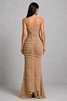 Woman wearing a brown textured dress against a gray background