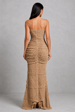 Woman wearing a brown textured dress against a gray background