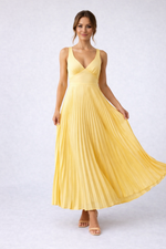 Woman wearing a yellow pleated dress on a white background