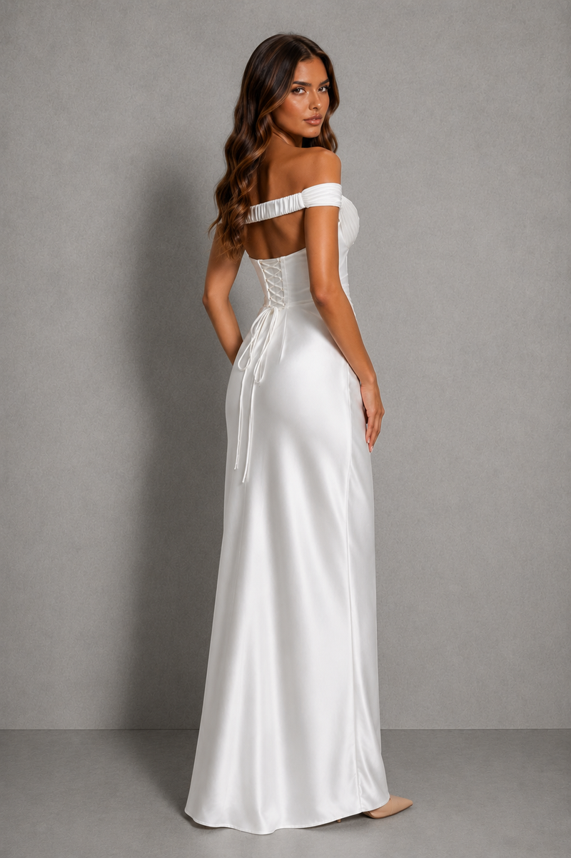 Woman wearing a white off-shoulder gown against a gray background
