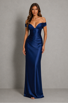 Woman wearing a blue off-shoulder gown against a gray background