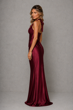 Woman wearing a burgundy evening gown against a gray background
