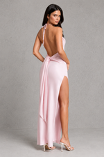 Woman wearing a pink open-back dress with a gray background