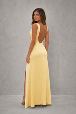 Woman wearing a yellow evening gown with a gray background