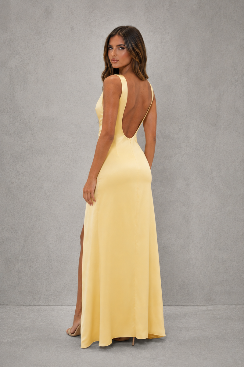 Woman wearing a yellow evening gown with a gray background