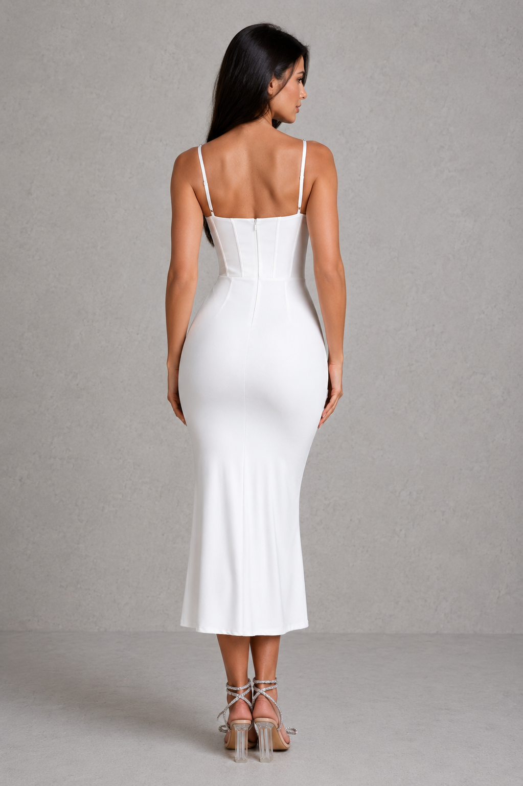 Woman wearing a white dress against a gray background