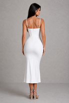 Woman wearing a white dress against a gray background