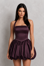 Woman wearing a purple dress against a gray background