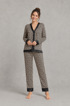 Women's brown satin two-piece pyjama set with a geometric print, long sleeve button-up V-neck top and matching full-length trousers.