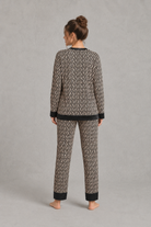 Women's brown satin two-piece pyjama set with a geometric print, long sleeve button-up V-neck top and matching full-length trousers.