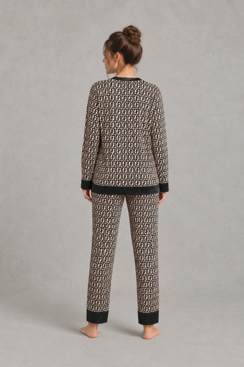 Women's brown satin two-piece pyjama set with a geometric print, long sleeve button-up V-neck top and matching full-length trousers.