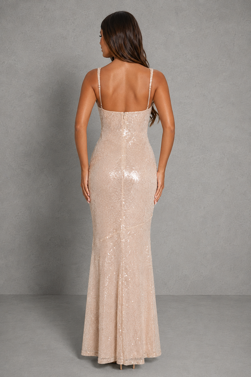 Woman wearing a beige sequin evening gown against a gray background