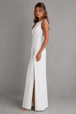 Woman wearing a white sleeveless dress with a slit on a gray background