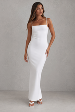 Woman wearing a white dress against a gray background