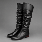 Women's black slouch knee-high boots with a low block heel, smooth PU leather upper, relaxed slouch design and durable rubber sole, ideal for everyday autumn and winter wear.
