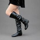 Women's black slouch knee-high boots with a low block heel, smooth PU leather upper, relaxed slouch design and durable rubber sole, ideal for everyday autumn and winter wear.