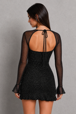 Black dress with sheer sleeves and open back on a gray background