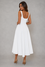 Woman wearing a white dress against a gray background