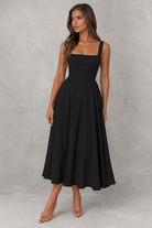 Woman wearing a black dress against a gray background