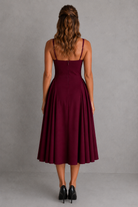 Woman wearing a burgundy dress against a gray background