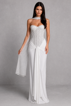 Woman wearing a strapless white gown with a gray background